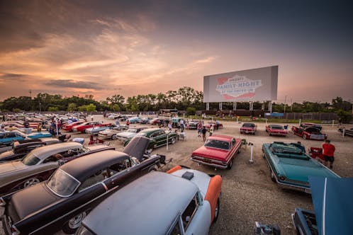 Drive In Theater Lot Filled with Classic Cars at Dusk