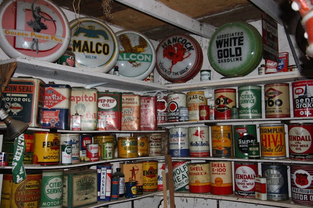 vintage oil cans and signs on shelves