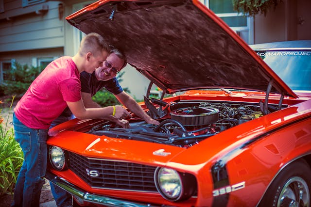 Father and Son Under Camaro Engine Bay