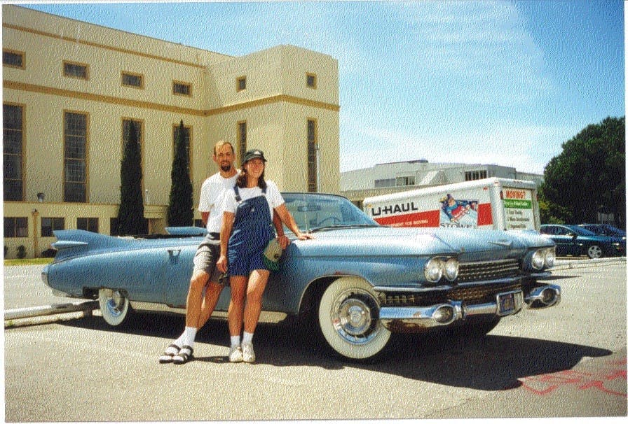man and woman with old vintage cadillac uhaul