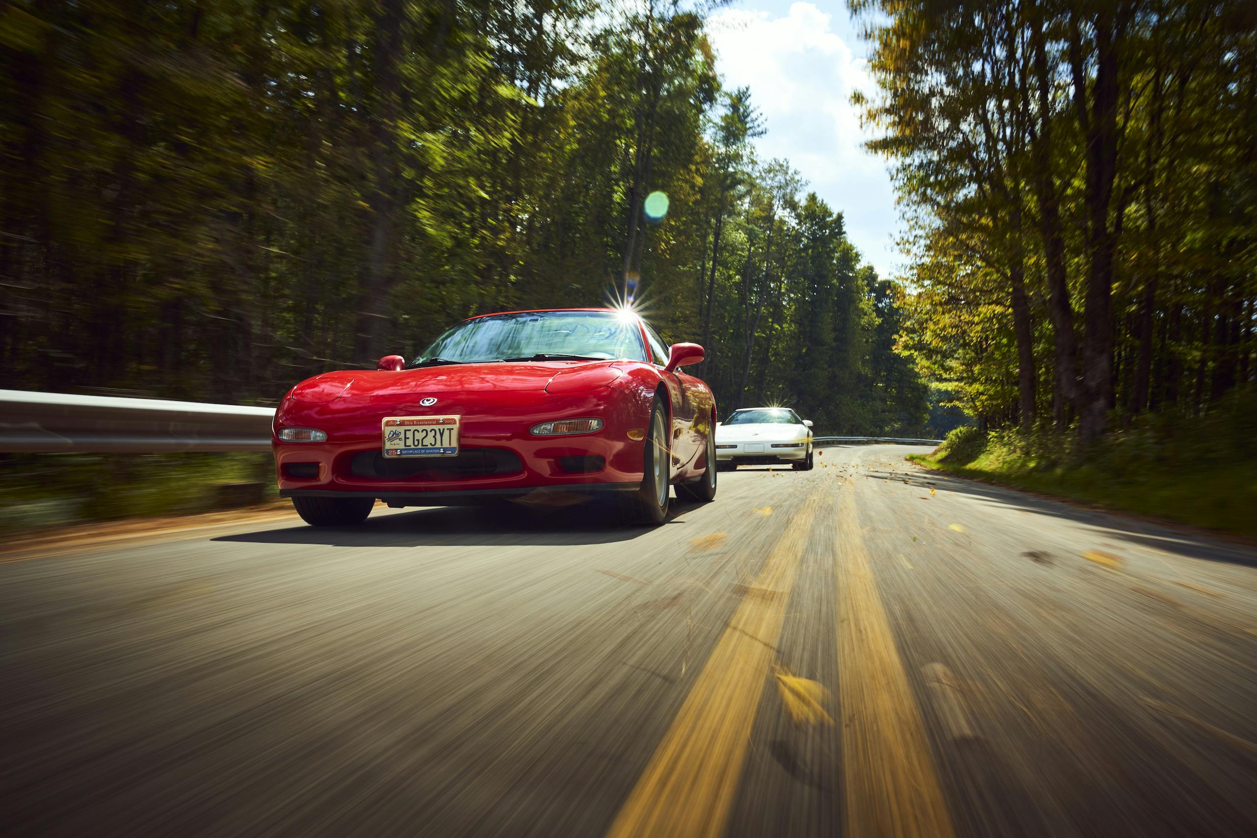 Mazda RX-7 with C4 Corvette trailing dynamic road action front