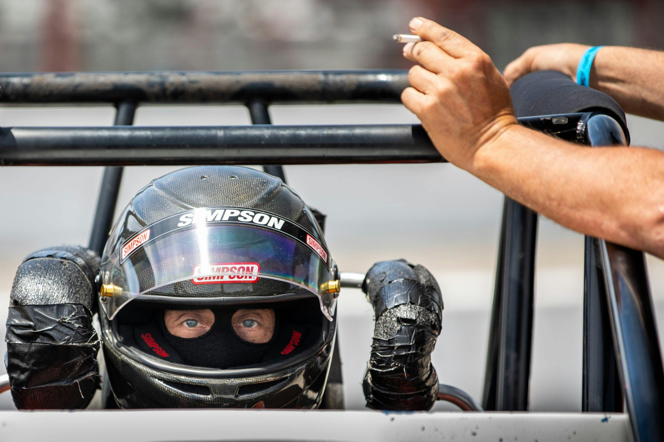 racecar driver simpson ready in cockpit near cigarette pit hand