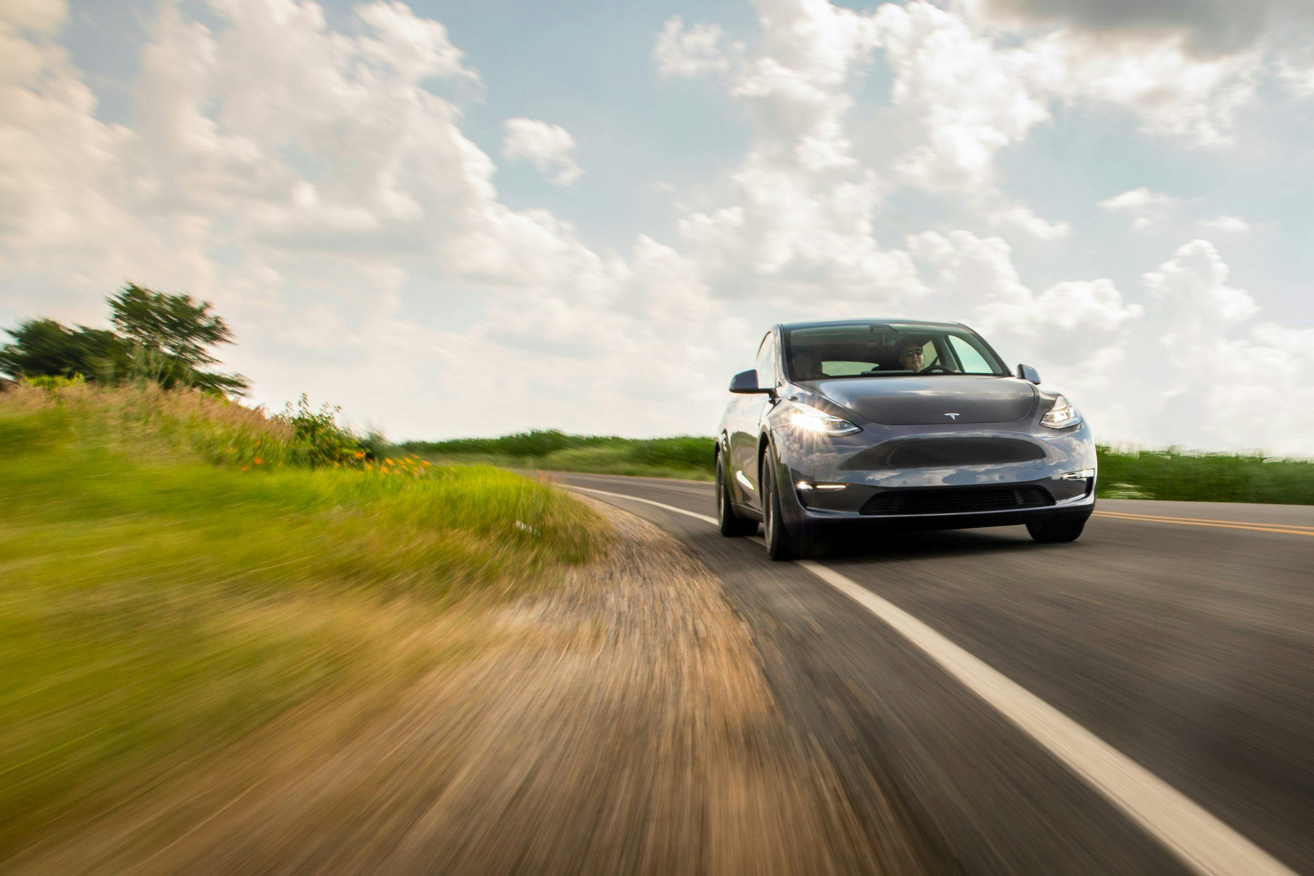 Tesla Model Y front three-quarter dynamic road action