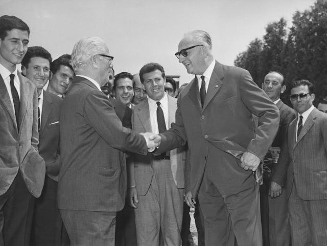 designer farina and mogul enzo ferrari shaking hands 1958