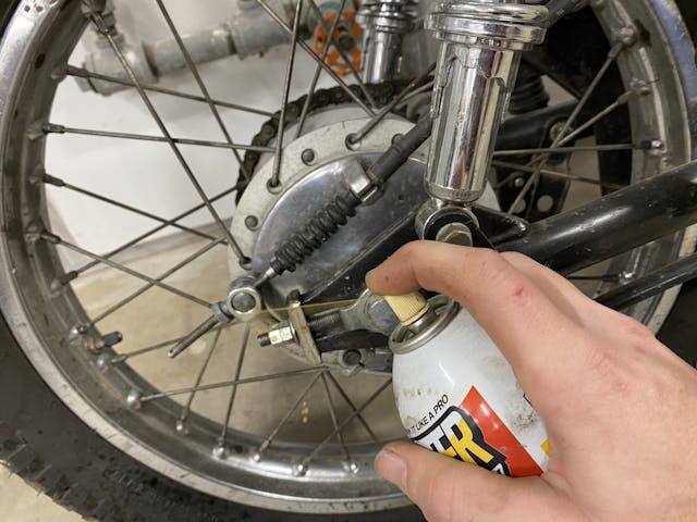 spraying oil on motorcycle