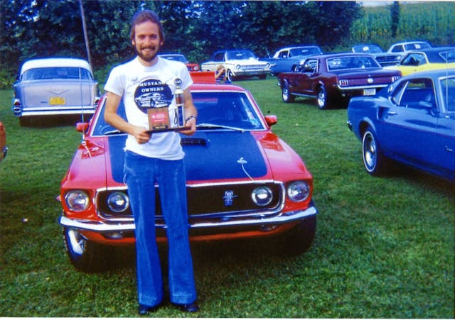 1969 Ford Mustang Mach 1 owner holding trophy