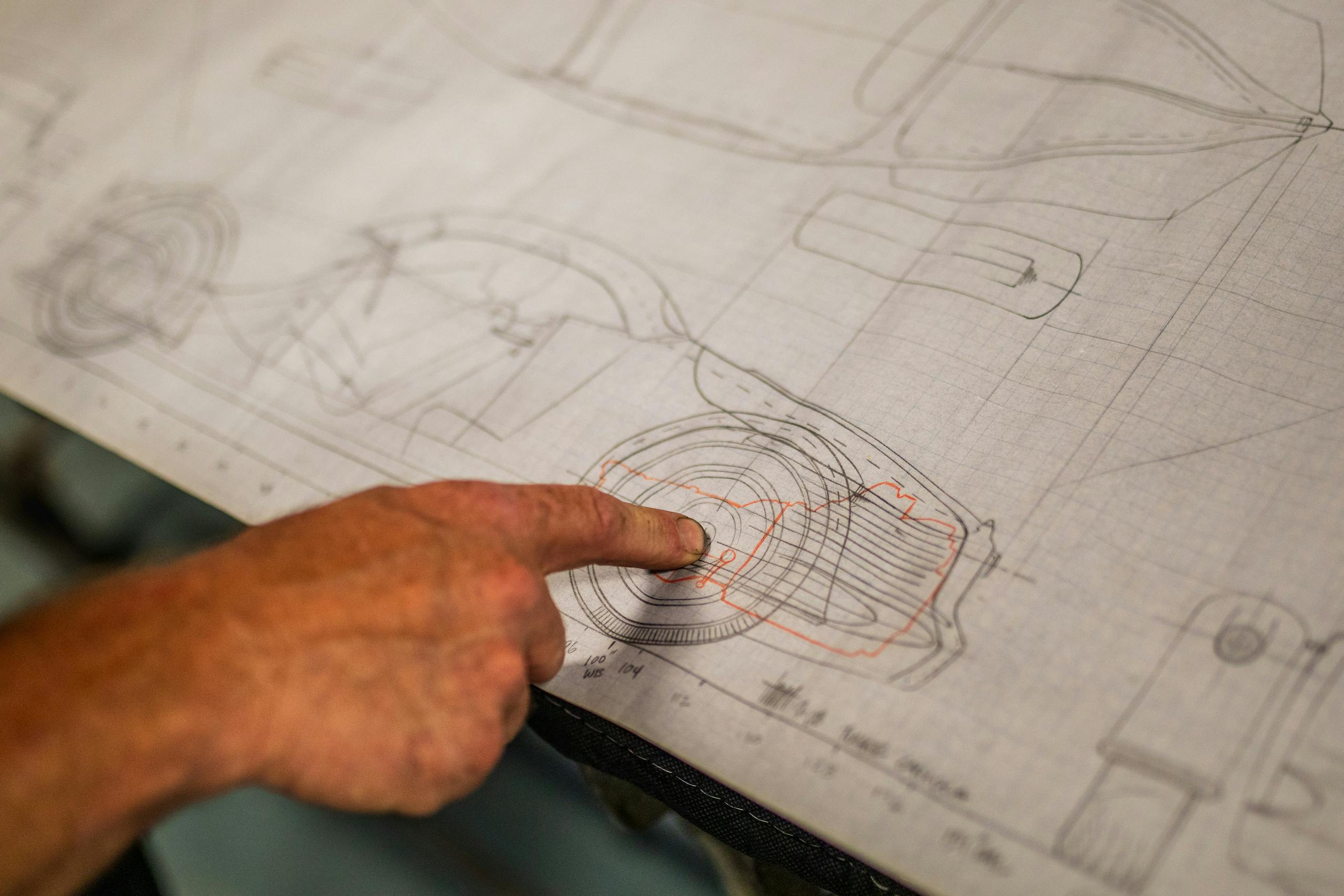 finger pointing to wheel on design drawing