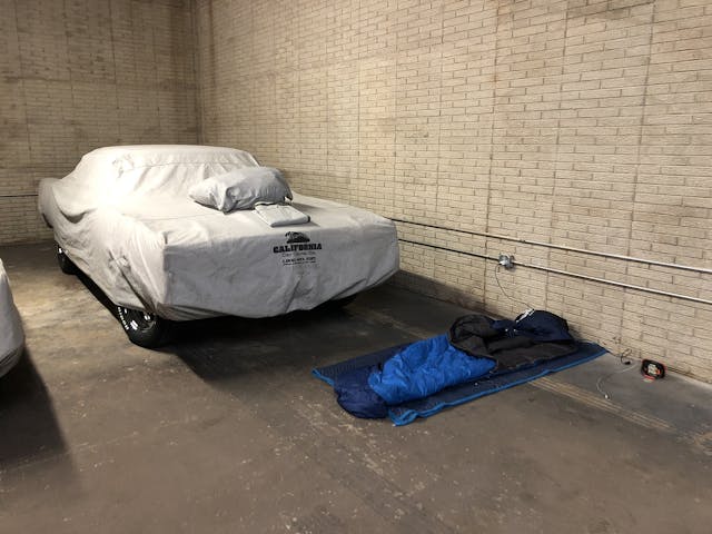 Sleeping bag in garage beside covered car