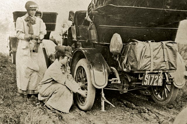 alice ramsey stops kneels changes tire on maxwell automobile