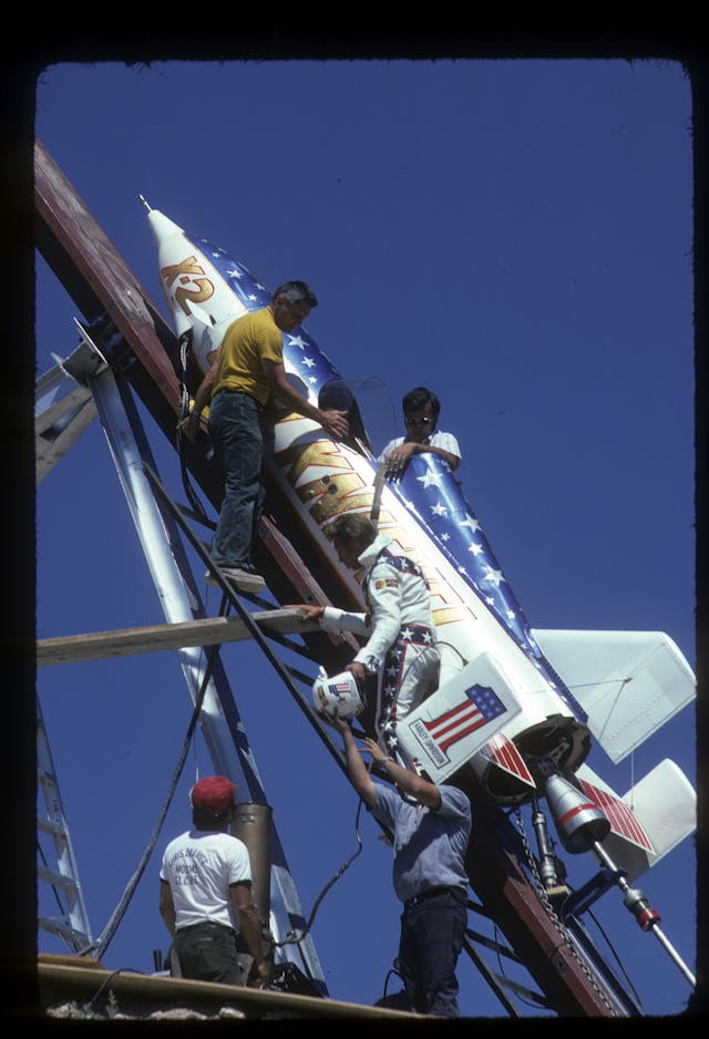 Evel Knievel with crew climbing into steam powered rocket