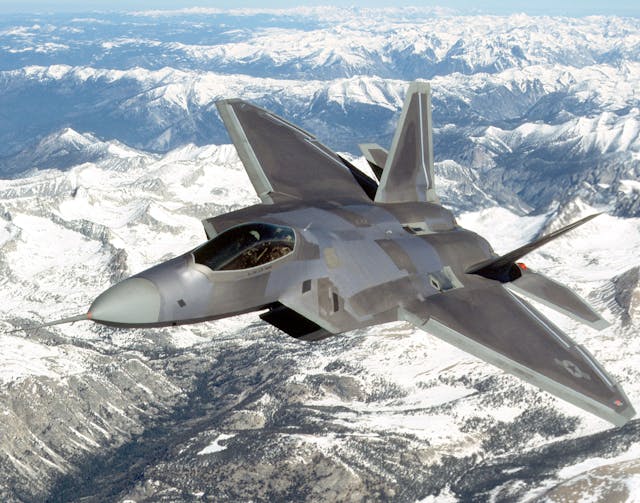 Air Force F-22 Raptor in sky over snowcapped mountains