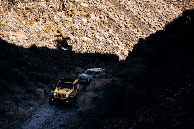 land rover defender following jeep wrangler rubicon up mountain two track