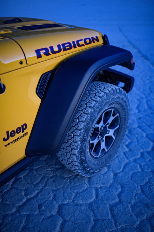 jeep wrangler rubicon front wheel and tire on blue desert floor