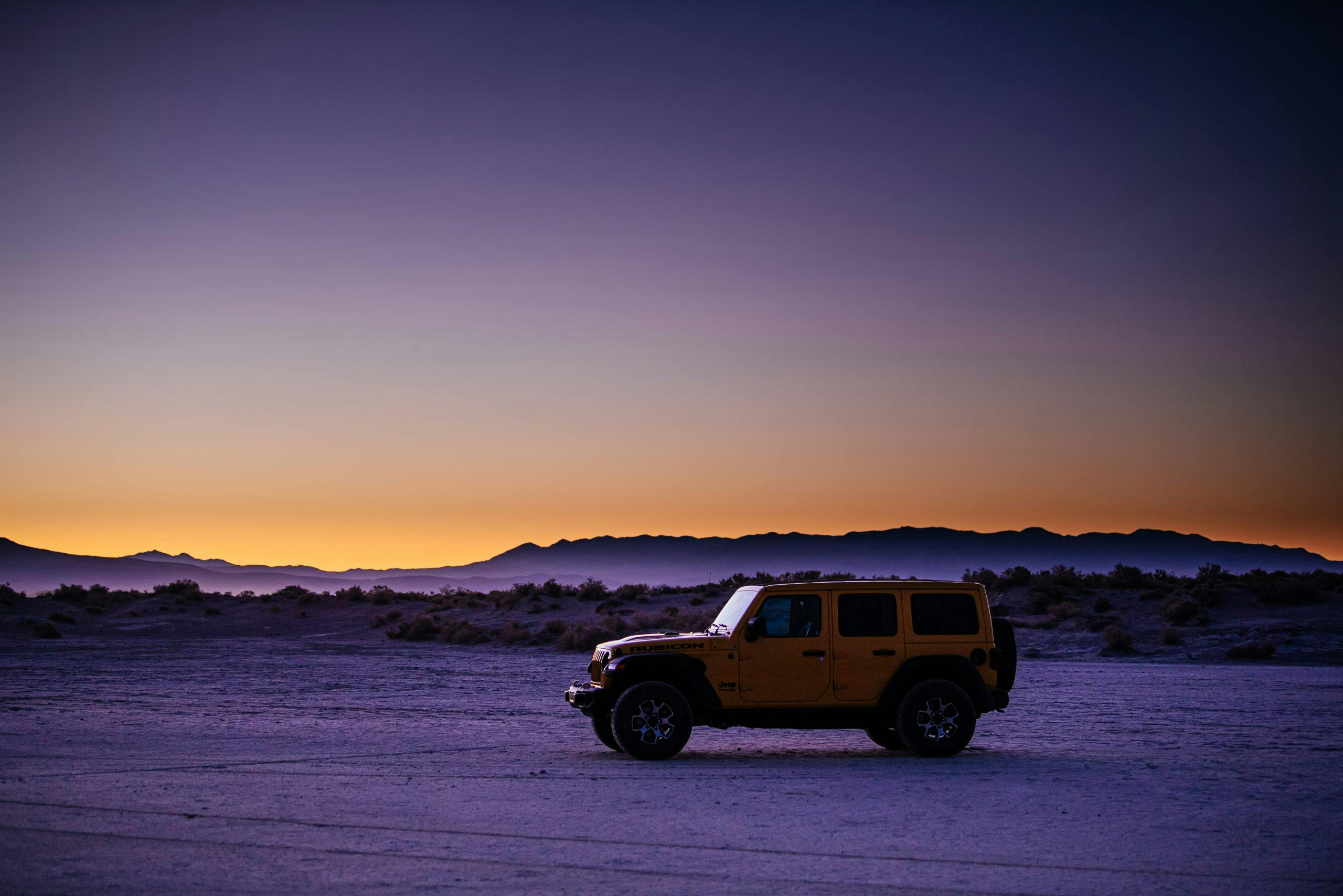 jeep wrangler rubicon side profile on desert flat at sundown