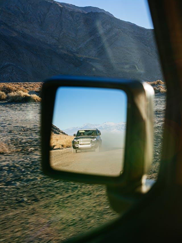 land rover defender in jeep rubicon rear view mirror vertical crop