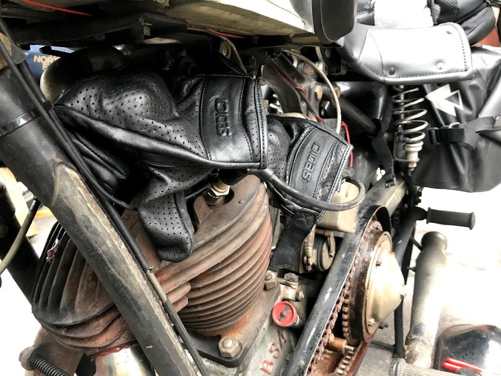 pre-war motorcycle cannonball gloves over engine