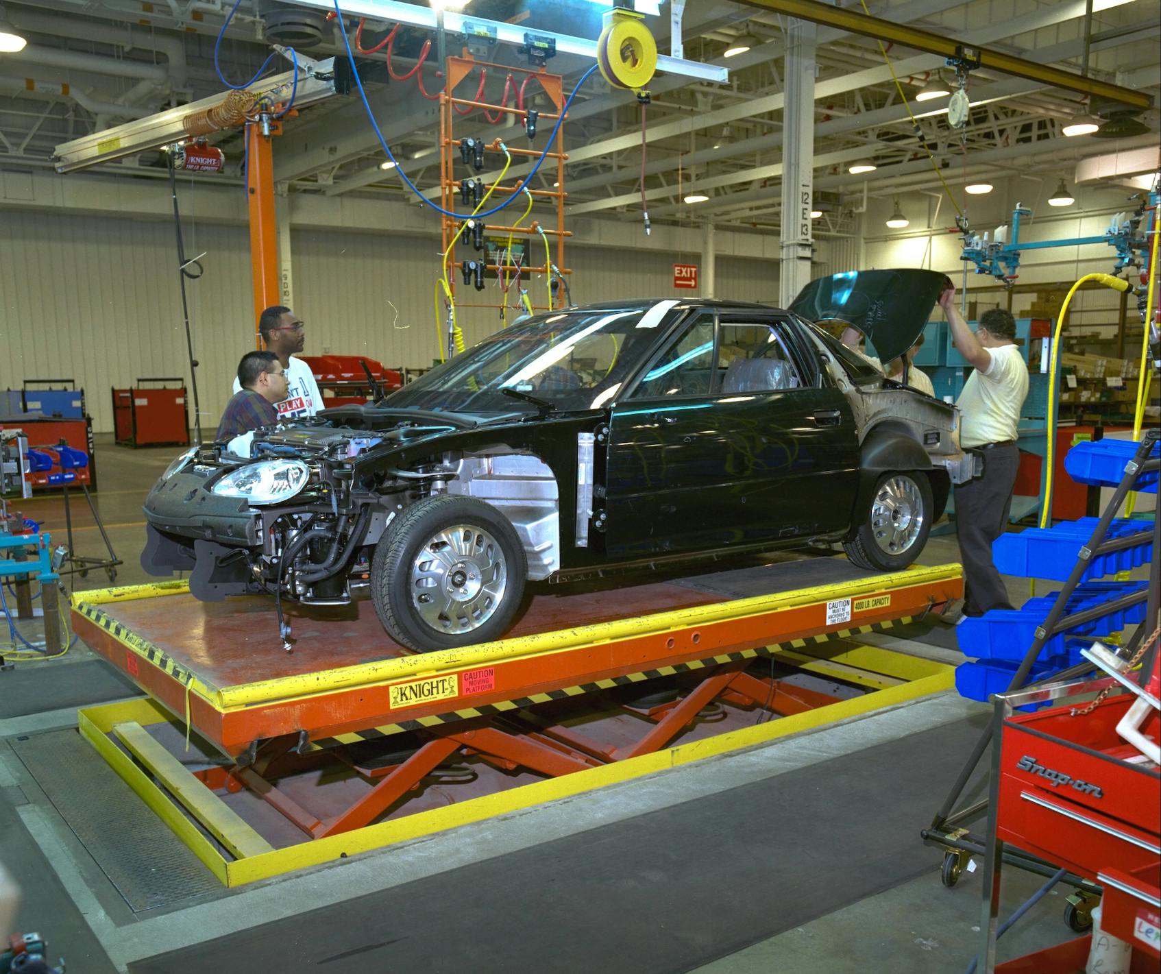 Workers assembling early GM electric car