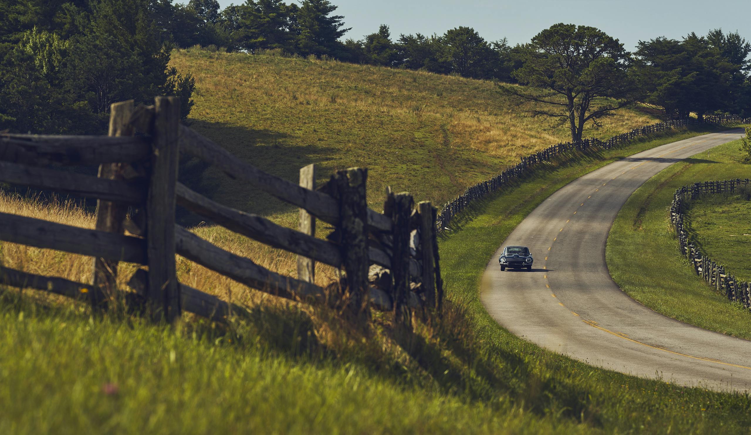 Jaguar E-Type front rural road fence