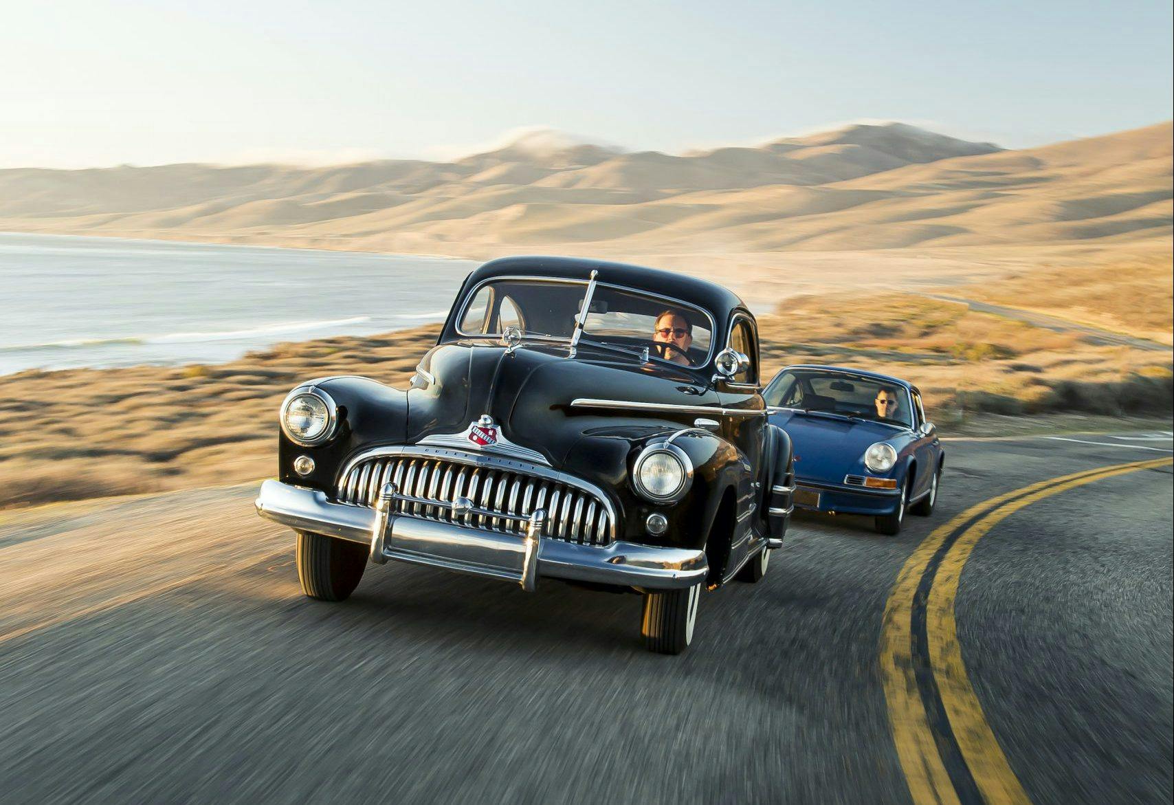 1946 Buick Special and 1970 Porsche 911 driving action vertical