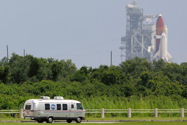 Space Shuttle Discovery astronauts ride in the astrovan