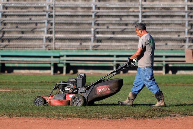 California Recreation Parks Worker mows playing field lawn
