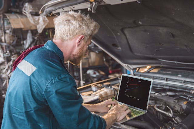 Car mechanic using computer in auto repair shop