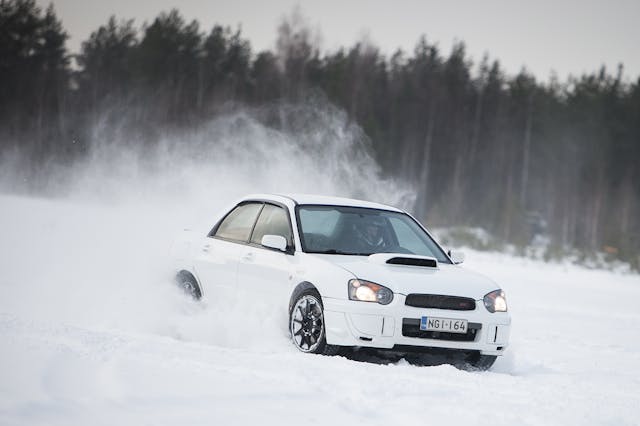white subaru sti front three-quarter snow driving action