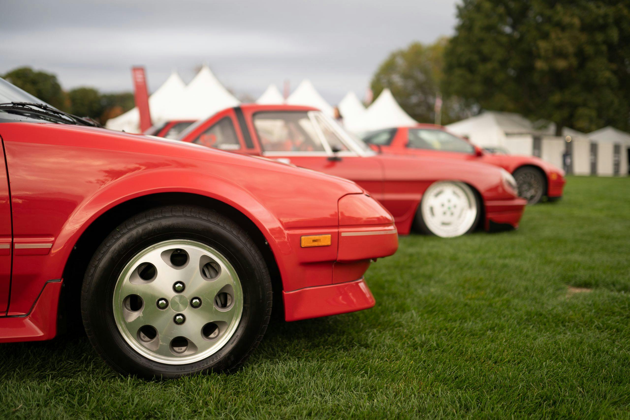 Three red cars line the show field at RADwood event