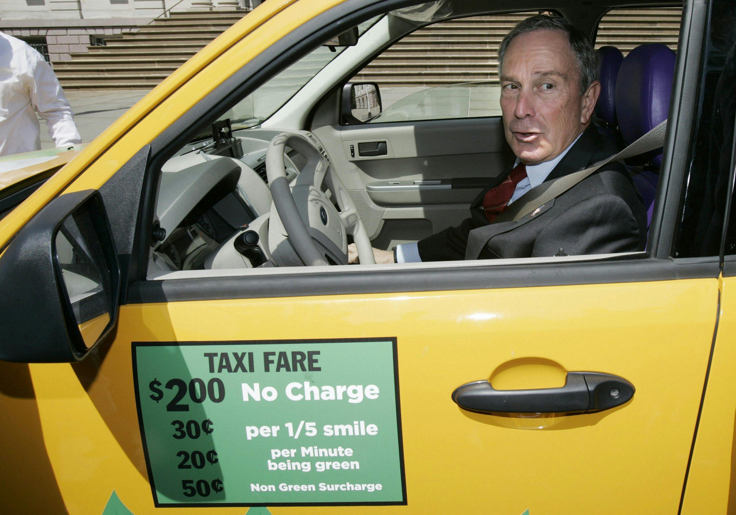 Mike Bloomberg sitting in a Ford Escape hybrid taxicab
