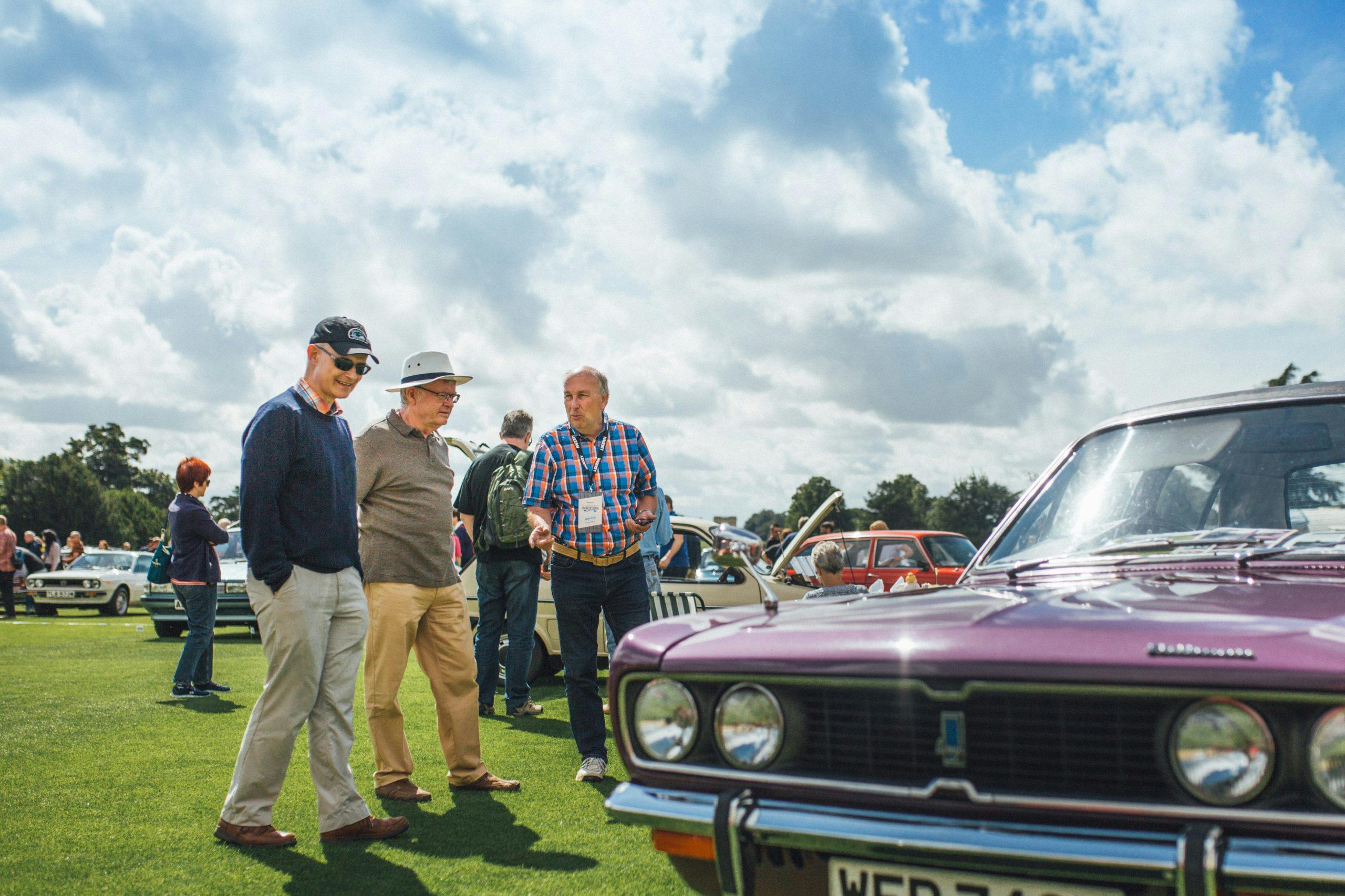 Group gathers to look at car at Concours de l’Ordinaire
