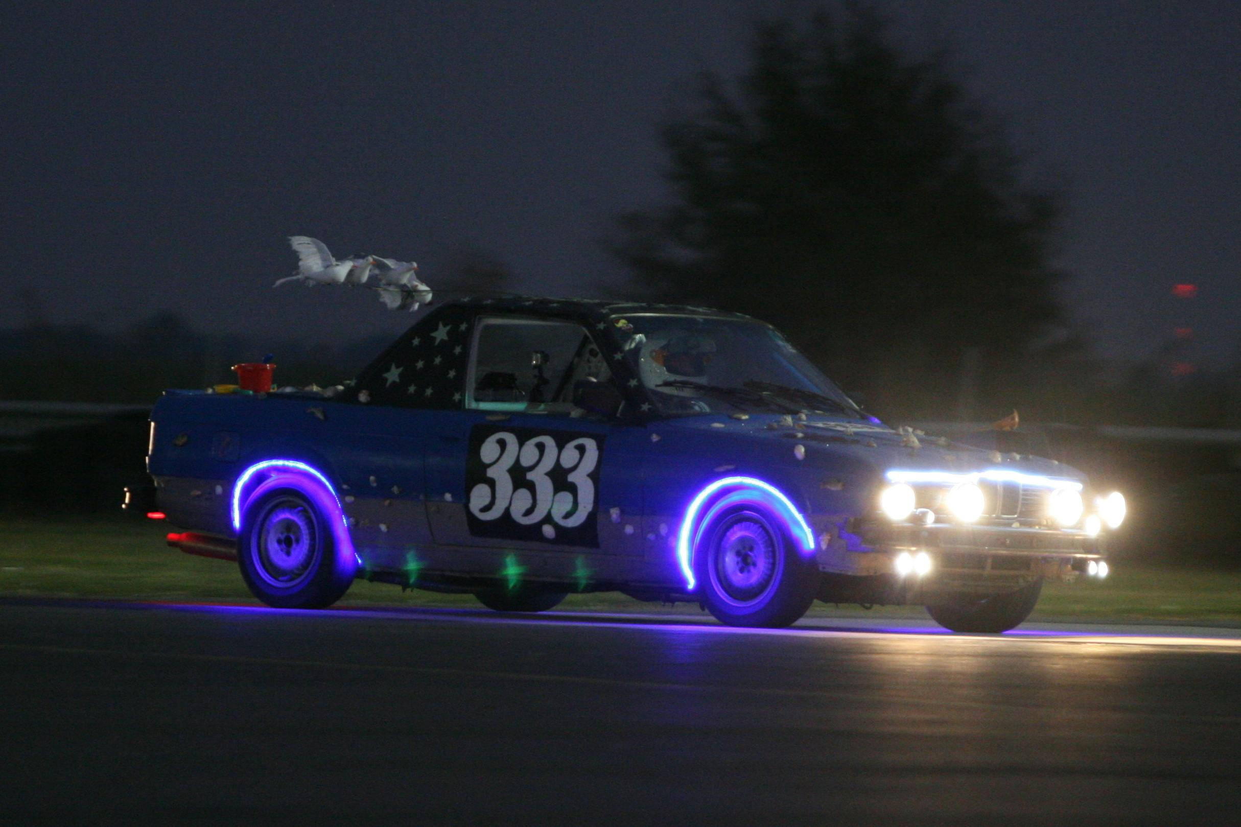 Car lined with lights races at night in the 24 Hours of Lemons
