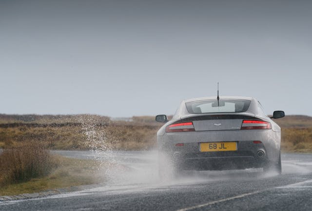 Aston Martin V8 Vantage rear driving action rainy day