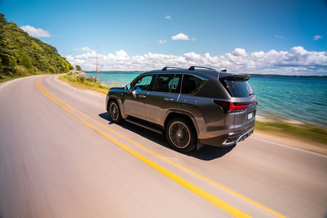 2022 Lexus LX 600 F Sport exterior rear side profile lakeside driving