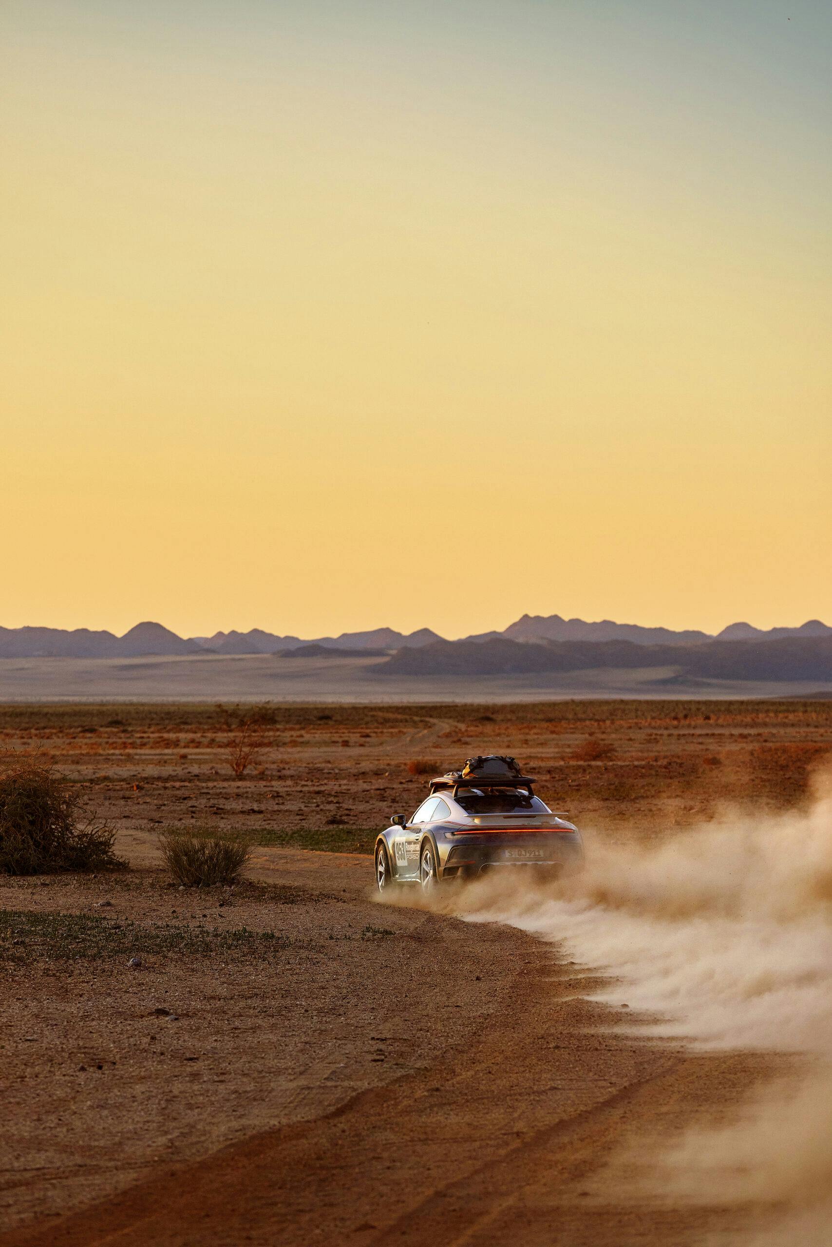 Porsche 911 Dakar rear three-quarter off-road action vertical