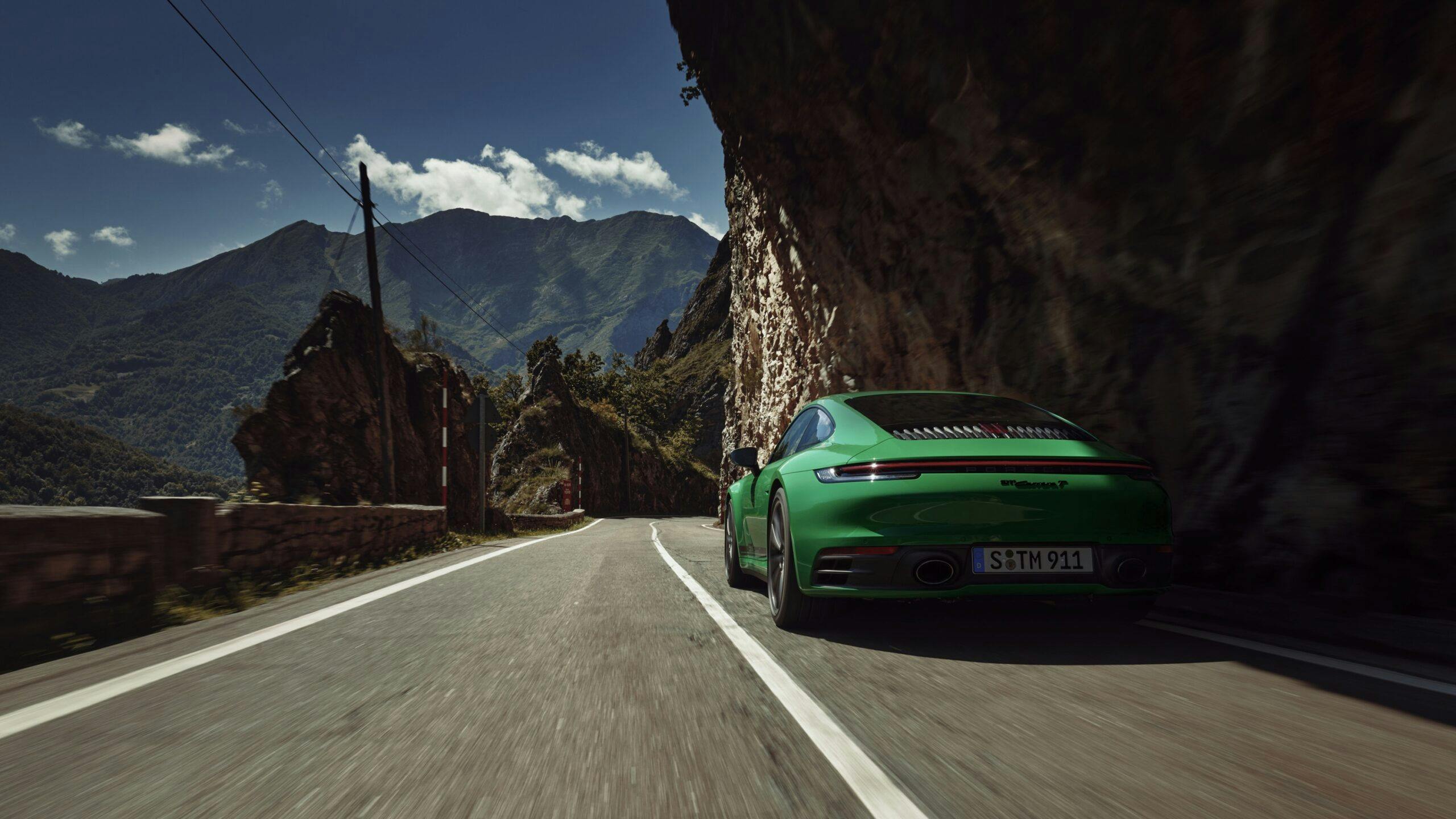 2023 Porsche 911 Carrera T green front rear quarter driving action