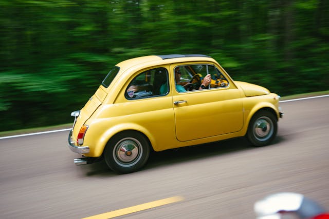 Yellow microcar side view dynamic pan action