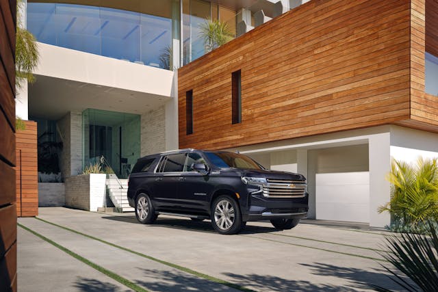 2023 Suburban High Country parked outside outlandishly fancy home marketing image