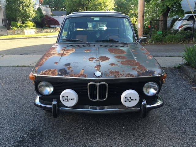 old bmw patina circles outside in driveway