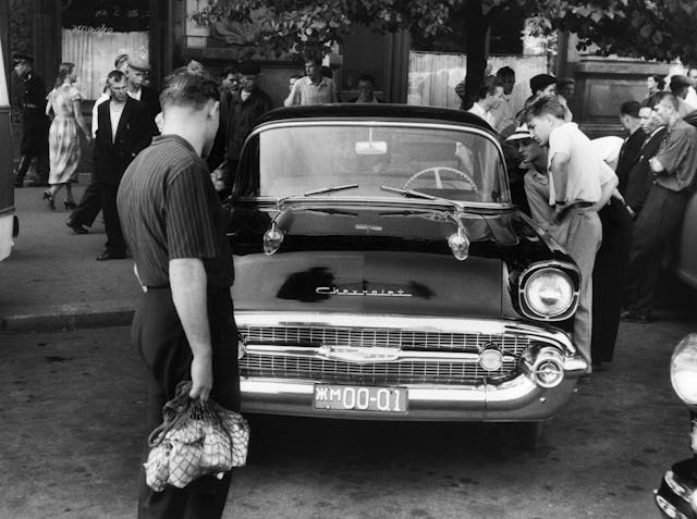 Pedestrians admire a brand new American Chevrolet automobile outside a hotel in Moscow