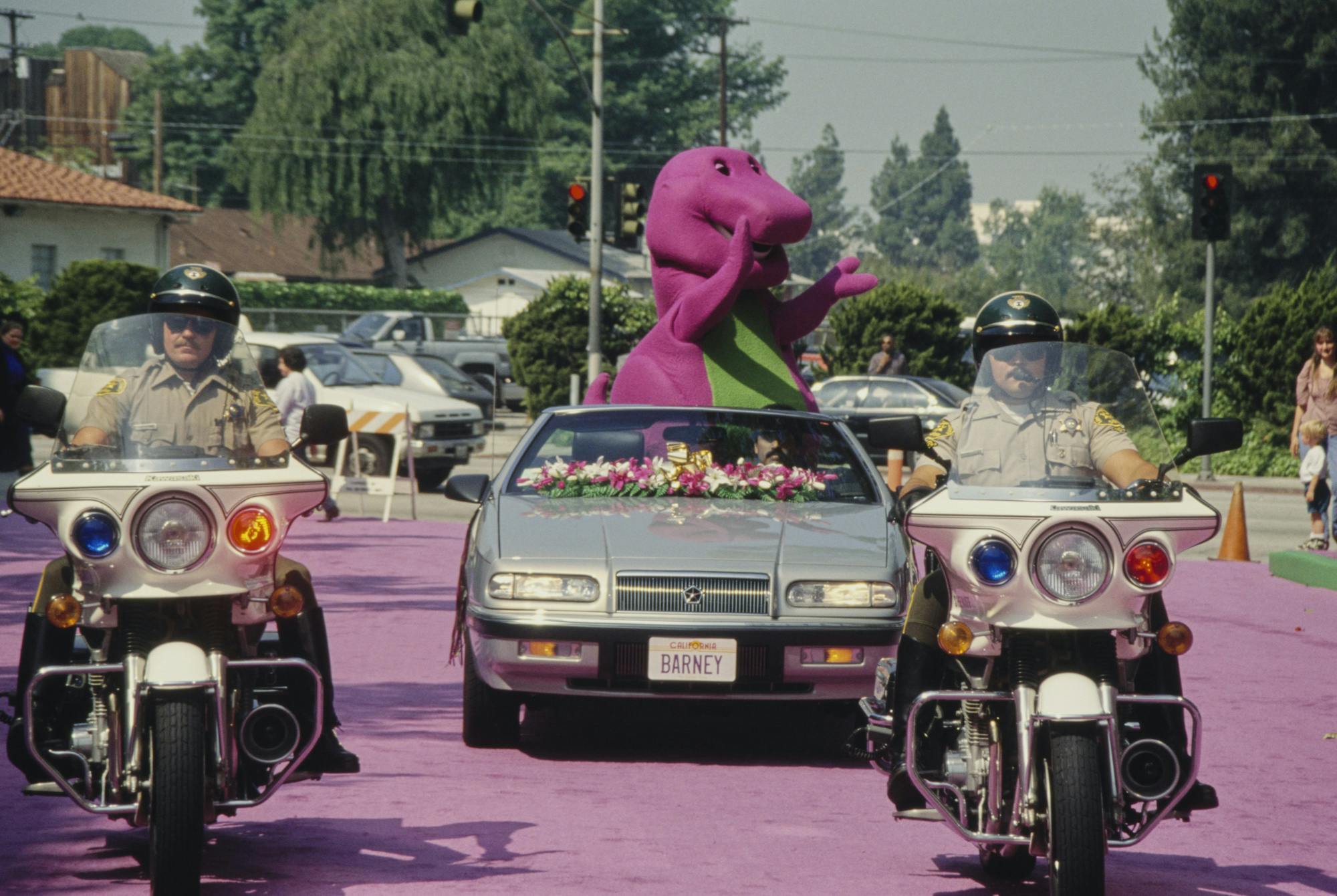 Barney the Dinosaur in a car because he is a boss