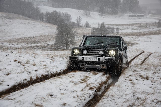 2023 Ineos Grenadier two track action snow-capped hills