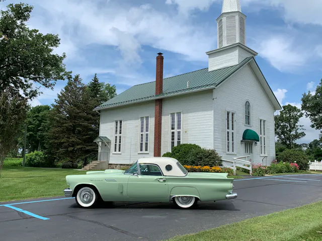 1957 Ford Thunderbird side view wide church parking lot