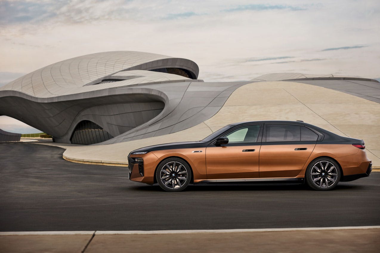 2024 BMW i7 M70 xDrive exterior side profile in front of curved building