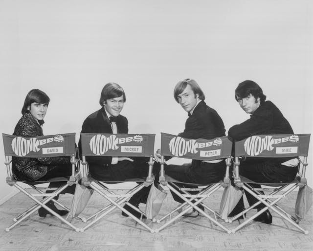 Music Group The Monkees Posing in Stage Chairs