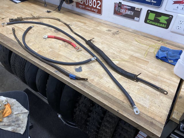old and new battery cables on bench