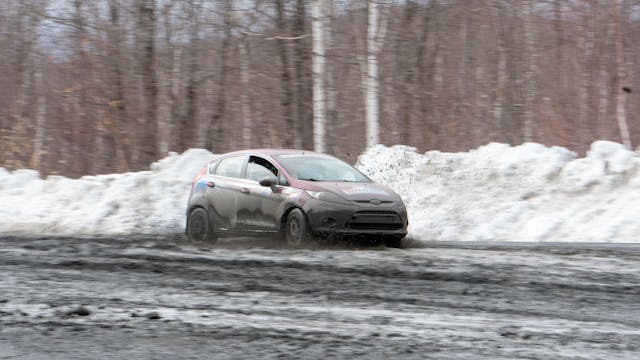 Team O'Neil rally school Ford Fiesta front three quarter spraying mud