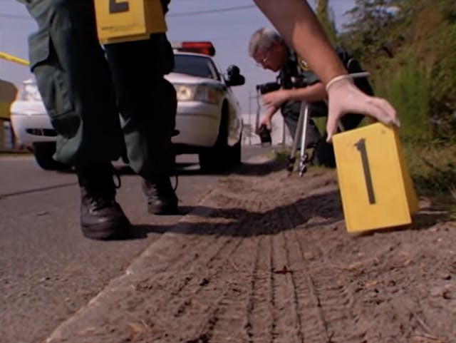 Police prepare to photograph tire tracks at a crime scene