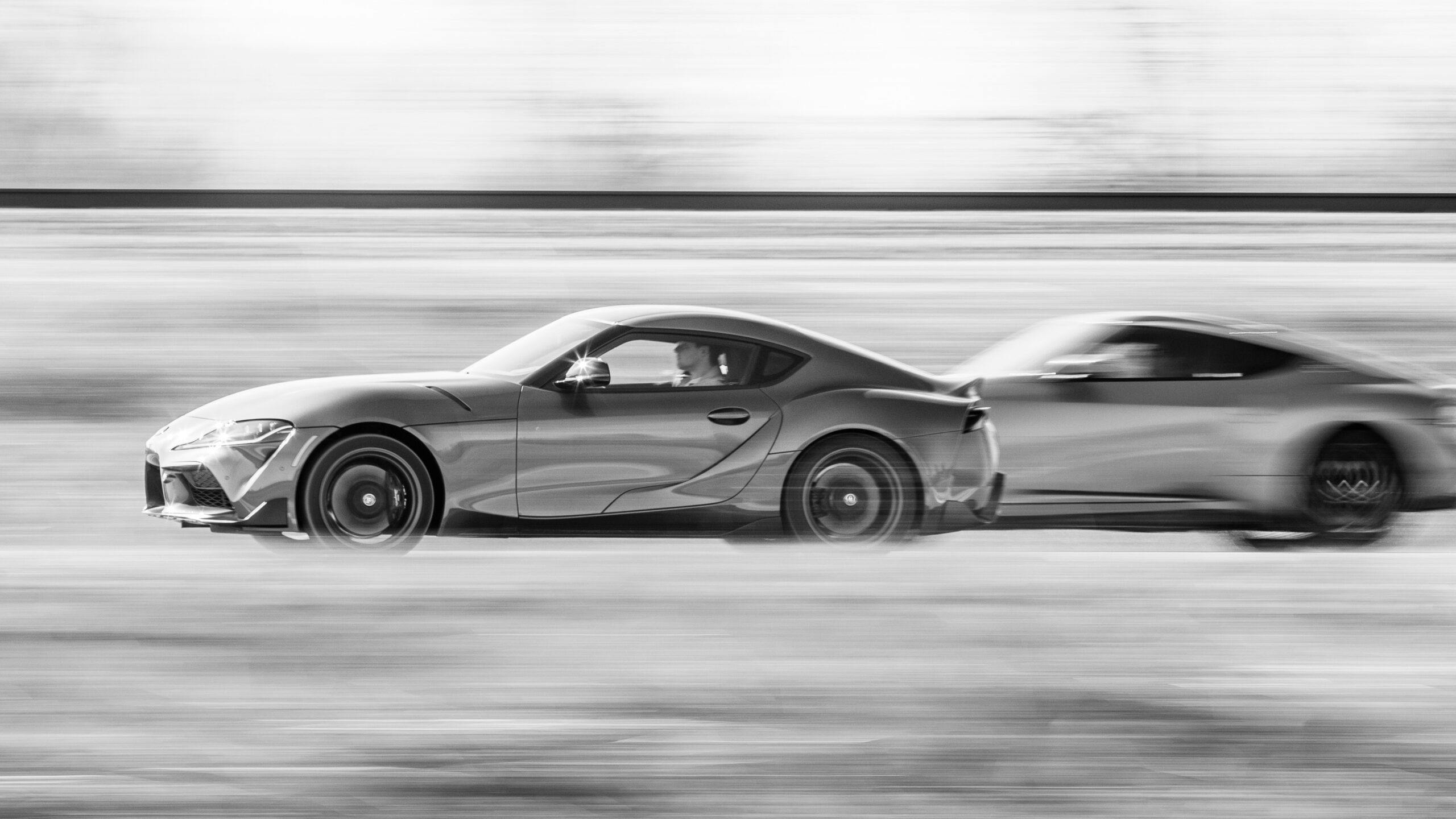 2023 Toyota Supra and 2023 Nissan Z Performance black white side pan action