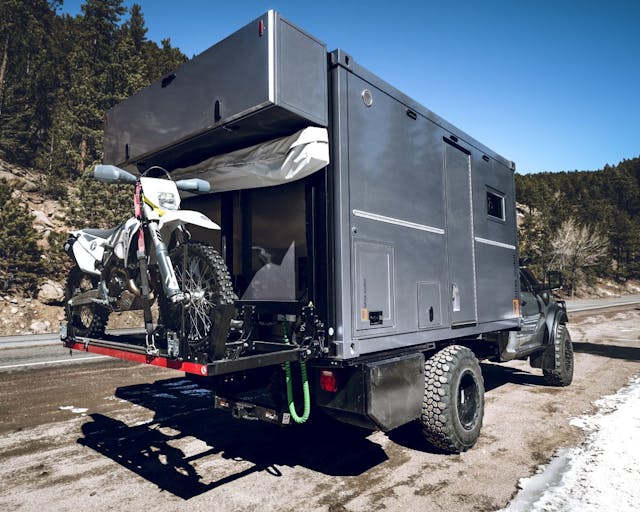 AEV x Bliss Mobil Prospector XL 550 exterior rear three quarter with dirt bike attached