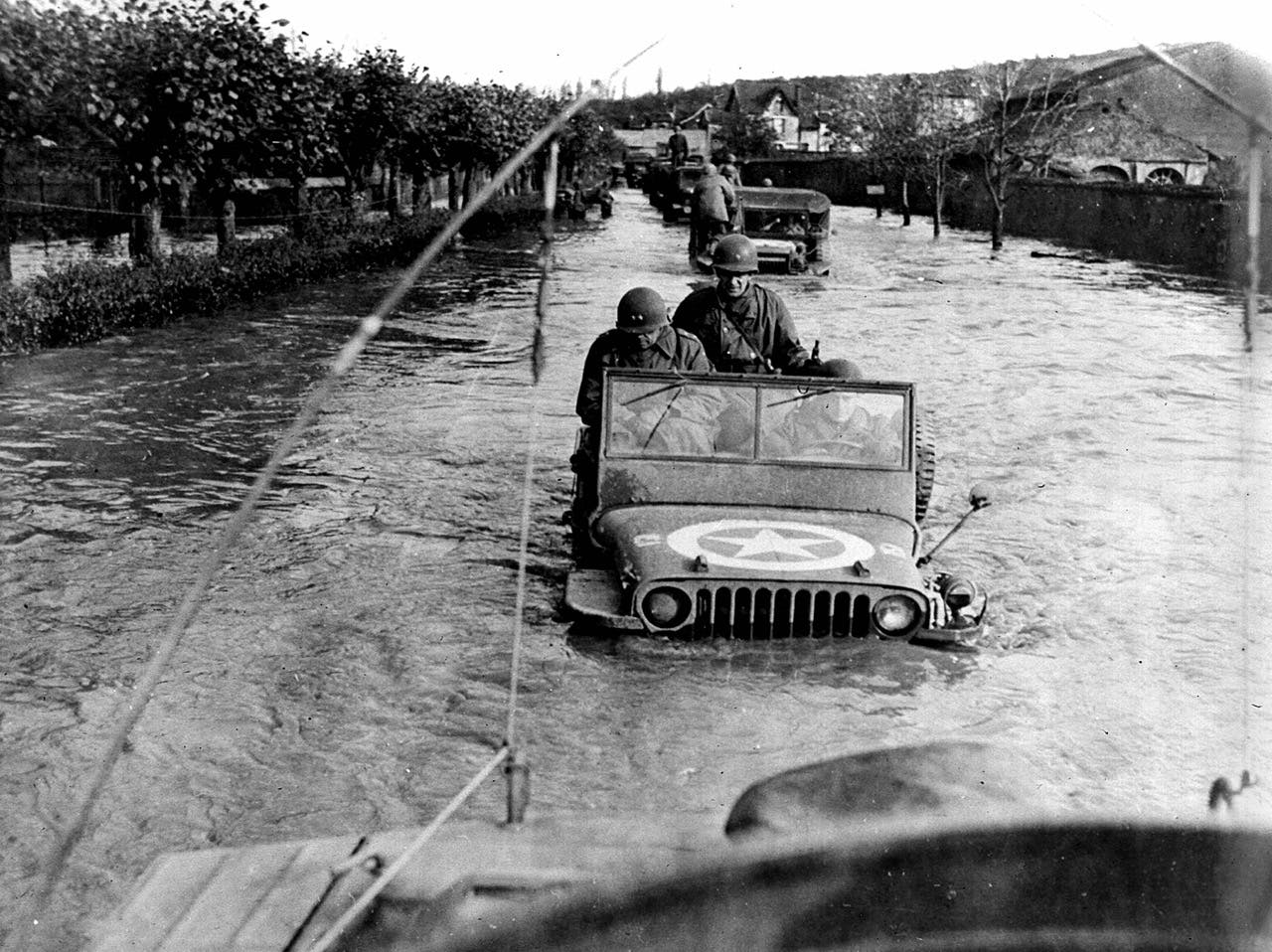 American convoy driving on flooded road in Jeeps